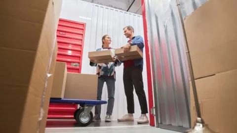 Couple organizing moving boxes inside a self-storage unit