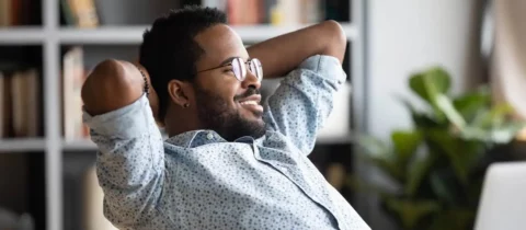 smiling man relaxing at his desk
